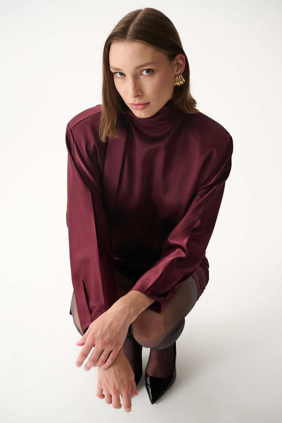Burgundy satin mini dress with long sleeves, high neck, and draped scarf detail